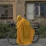 
              An Afghan woman poses for a photo with her bicycle in Kabul, Afghanistan, Monday, Sept. 19, 2022. The ruling Taliban have banned women from sports as well as barring them from most schooling and many realms of work. A number of women posed for an AP photographer for portraits with the equipment of the sports they loved. Though they do not necessarily wear the burqa in regular life, they chose to hide their identities with their burqas because they fear Taliban reprisals and because some of them continue to practice their sports in secret. (AP Photo/Ebrahim Noroozi)
            
