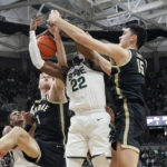 
              Michigan State center Mady Sissoko (22) and Purdue center Zach Edey (15) and Purdue forward Caleb Furst (1) reach for the rebound during the first half of an NCAA college basketball game, Monday, Jan. 16, 2023, in East Lansing, Mich. (AP Photo/Carlos Osorio)
            