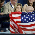 
              The U.S. ambassador to Australia Caroline Kennedy holds up her national flag as Australian Prime Minister Anthony Albanese watches during the semifinal between Tommy Paul of the U.S. and Novak Djokovic of Serbia at the Australian Open tennis championship in Melbourne, Australia, Friday, Jan. 27, 2023. (AP Photo/Asanka Brendon Ratnayake)
            