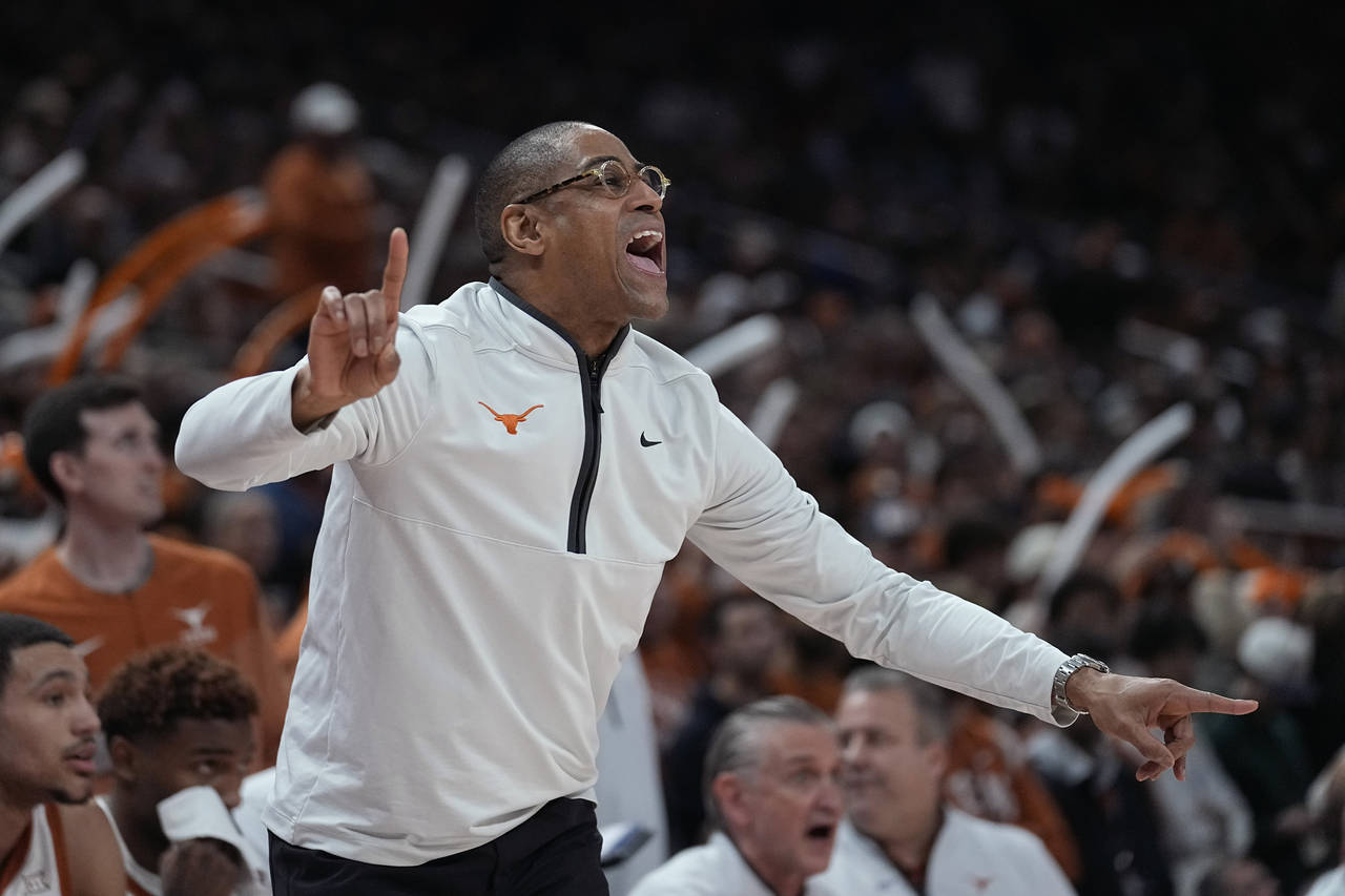 Texas interim coach Rodney Terry signals to players during the first half of the team's NCAA colleg...