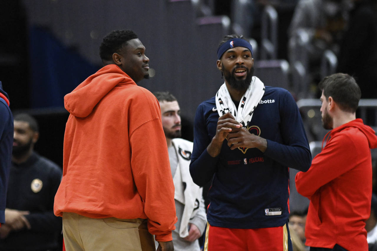 Injured New Orleans Pelicans forward Zion Williamson, left, talks with forward Naji Marshall, secon...