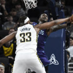 
              Indiana Pacers center Myles Turner (33) blocks a shot by Charlotte Hornets guard Terry Rozier, right, during the second half of an NBA basketball game, Sunday, Jan. 8, 2023, in Indianapolis. (AP Photo/Marc Lebryk)
            