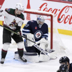 
              Arizona Coyotes center Barrett Hayton deflects a shot wide past Winnipeg Jets goaltender Connor Hellebuyck during the first period of an NHL hockey game in Winnipeg, Manitoba, on Sunday Jan. 15, 2023. (Fred Greenslade/The Canadian Press via AP)
            