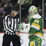 
              Minnesota Wild goaltender Filip Gustavsson (32) hands the puck to linesman Ryan Galloway (82) during the first period of an NHL hockey game against the St. Louis Blues, Sunday, Jan. 8, 2023, in St. Paul, Minn. (AP Photo/Stacy Bengs)
            