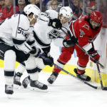 
              Carolina Hurricanes' Jalen Chatfield (5) shields the puck from Los Angeles Kings' Blake Lizotte and Quinton Byfield during the first period of an NHL hockey game in Raleigh, N.C., Tuesday, Jan. 31, 2023. (AP Photo/Karl B DeBlaker)
            