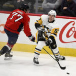 
              Pittsburgh Penguins center Sidney Crosby (87) passes the puck against Washington Capitals right wing T.J. Oshie (77) during the third period of an NHL hockey game, Thursday, Jan. 26, 2023, in Washington. (AP Photo/Nick Wass)
            