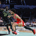
              Chicago Bulls guard Coby White, right, drives past Charlotte Hornets forward JT Thor (21) during the first half of an NBA basketball game in Charlotte, N.C., Thursday, Jan. 26, 2023. (AP Photo/Nell Redmond)
            