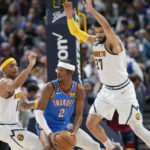 
              Oklahoma City Thunder guard Shai Gilgeous-Alexander, center, is trapped with the ball by Denver Nuggets forward Bruce Brown, left, and guard Jamal Murray in the first half of an NBA basketball game Sunday, Jan. 22, 2023, in Denver. (AP Photo/David Zalubowski)
            