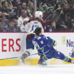 
              Vancouver Canucks' Jack Studnicka (18) loses his helmet after colliding with Colorado Avalanche's Brad Hunt (17) during the first period of an NHL hockey game Thursday, Jan. 5, 2023, in Vancouver, British Columbia. (Darryl Dyck/The Canadian Press via AP)
            