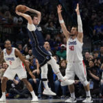 
              Dallas Mavericks guard Luka Doncic jumps to pass against Los Angeles Clippers defenders Ivica Zubac (40), Paul George (13) and Kawhi Leonard (2) during the first half of an NBA basketball game in Dallas, Sunday, Jan. 22, 2023. (AP Photo/LM Otero)
            
