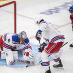 
              New York Rangers goaltender Jaroslav Halak, left, makes a save against Montreal Canadiens' Kirby Dach (77) as Rangers' Jacob Trouba, center, defends during third-period NHL hockey game action in Montreal, Thursday, Jan. 5, 2023. (Graham Hughes/The Canadian Press via AP)
            