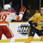 
              Calgary Flames center Jonathan Huberdeau (10) swats the puck away from Nashville Predators left wing Tanner Jeannot (84) during the second period of an NHL hockey game Monday, Jan. 16, 2023, in Nashville, Tenn. (AP Photo/Mark Zaleski)
            