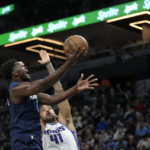 
              Minnesota Timberwolves guard Anthony Edwards, left, goes up to shoot while defended by Sacramento Kings forward Trey Lyles (41) during the first half of an NBA basketball game, Monday, Jan. 30, 2023, in Minneapolis. (AP Photo/Abbie Parr)
            