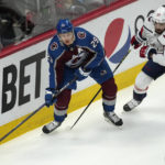 
              Colorado Avalanche center Nathan MacKinnon, left, looks to pass the puck as Washington Capitals defenseman Erik Gustafsson covers in the first period of an NHL hockey game Tuesday, Jan. 24, 2023, in Denver. (AP Photo/David Zalubowski)
            
