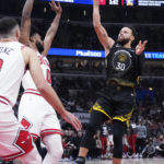 
              Golden State Warriors guard Stephen Curry, right, shoots against Chicago Bulls guards Coby White (0) and Zach LaVine, left, during the first half of an NBA basketball game in Chicago, Sunday, Jan. 15, 2023. (AP Photo/Nam Y. Huh)
            