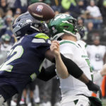 
              Seattle Seahawks defensive end Darrell Taylor, left, forces New York Jets quarterback Mike White (5) to fumble during the first half of an NFL football game, Sunday, Jan. 1, 2023, in Seattle. The Seahawks recovered the ball. (AP Photo/Ted S. Warren)
            