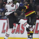 
              Chicago Blackhawks' MacKenzie Entwistle, left, and Vancouver Canucks' William Lockwood collide during the first period of an NHL hockey game Tuesday, Jan. 24, 2023, in Vancouver, British Columbia. (Darryl Dyck/The Canadian Press via AP)
            