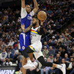 
              Minnesota Timberwolves guard D'Angelo Russell (0) passes the ball under pressure from Los Angeles Clippers Moses Brown (9) during the second half of an NBA basketball game Friday, Jan. 6, 2023, in Minneapolis. (AP Photo/Andy Clayton-King)
            