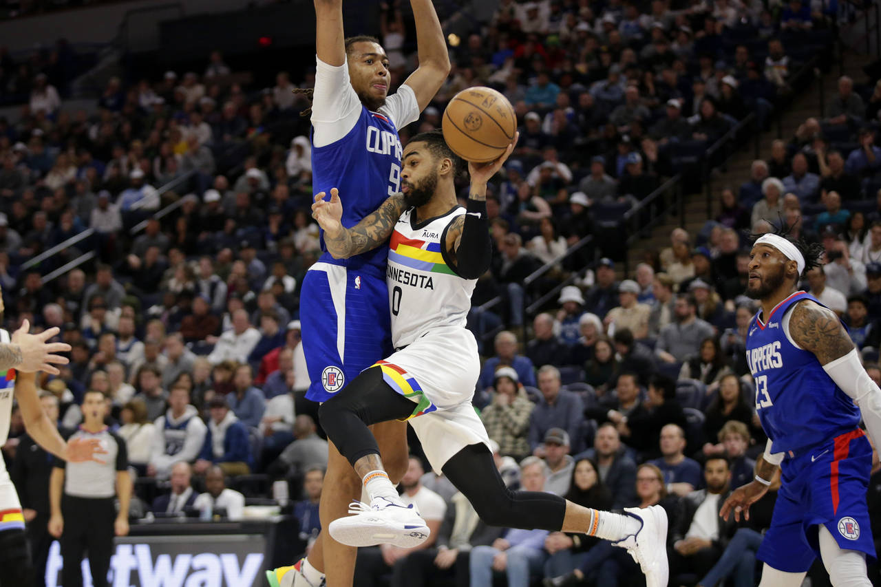 Minnesota Timberwolves guard D'Angelo Russell (0) passes the ball under pressure from Los Angeles C...