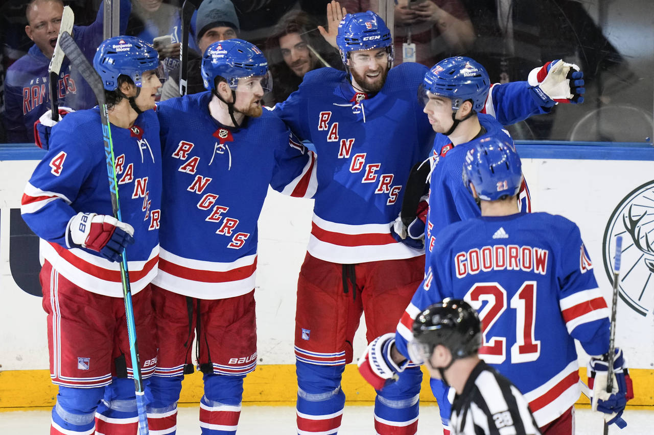 New York Rangers' Ben Harpur, center, celebrates with teammates after scoring a goal during the thi...