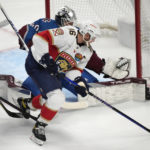 
              Florida Panthers center Aleksander Barkov, front, brings the puck past Colorado Avalanche goaltender Alexandar Georgiev to score a goal in the first period of an NHL hockey game Tuesday, Jan. 10, 2023, in Denver. (AP Photo/David Zalubowski)
            