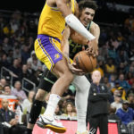 
              Los Angeles Lakers forward Troy Brown Jr. and Charlotte Hornets guard LaMelo Ball vie for the ball during the first half of an NBA basketball game between the Charlotte Hornets and the Los Angeles Lakers on Monday, Jan. 2, 2023, in Charlotte, N.C. (AP Photo/Chris Carlson)
            