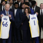 
              President Joe Biden and Vice President Kamala Harris hold up team jerseys as they welcome the 2022 NBA champions, the Golden State Warriors, to the East Room of the White House in Washington, Tuesday, Jan 17, 2023. (AP Photo/Susan Walsh)
            