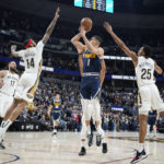 
              Denver Nuggets forward Michael Porter Jr., center, drives to the rim between New Orleans Pelicans forward Brandon Ingram, left, and guard Trey Murphy III in the first half of an NBA basketball game Tuesday, Jan. 31, 2023, in Denver. (AP Photo/David Zalubowski)
            