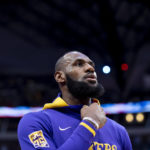 
              Los Angeles Lakers forward LeBron James peers at the American flag during the national anthem prior to the start of an NBA basketball game in Dallas, Sunday, Dec. 25, 2022. (AP Photo/Emil T. Lippe)
            