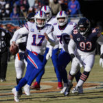 
              Buffalo Bills quarterback Josh Allen (17) is chased out of the pocket by Chicago Bears defensive lineman Justin Jones (93) in the first half of an NFL football game in Chicago, Saturday, Dec. 24, 2022. (AP Photo/Charles Rex Arbogast)
            