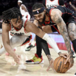 
              Portland Trail Blazers forward Trendon Watford, left, and Toronto Raptors guard Gary Trent Jr. go after the ball during the first half of an NBA basketball game in Portland, Ore., Saturday, Jan. 28, 2023. (AP Photo/Steve Dykes)
            