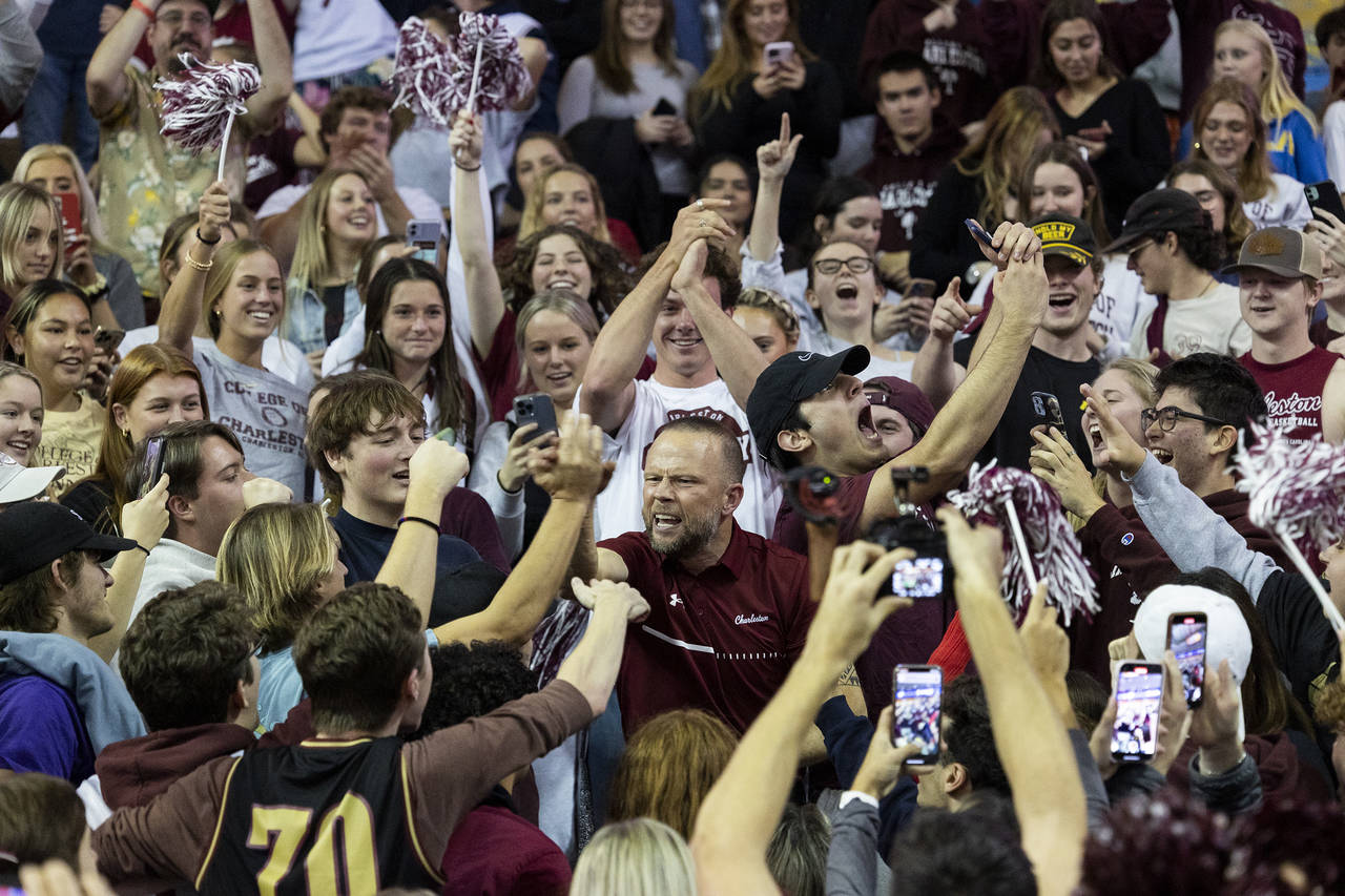 FILE - College of Charleston head coach Pat Kelsey, center, celebrates with students after defeatin...