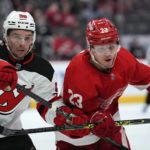 
              New Jersey Devils left wing Erik Haula (56) and Detroit Red Wings left wing Lucas Raymond (23) battle for position in the second period of an NHL hockey game Wednesday, Jan. 4, 2023, in Detroit. (AP Photo/Paul Sancya)
            