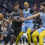 
              Sacramento Kings guard Malik Monk, left, is guarded by Memphis Grizzlies forward Ziaire Williams (8) and David Roddy (27) during the first quarter of an NBA basketball game in Sacramento, Calif., Monday, Jan. 23, 2023. (AP Photo/Randall Benton)
            