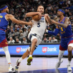 
              Minnesota Timberwolves forward Kyle Anderson (5) drives past Denver Nuggets forward Bruce Brown (11) and Kentavious Caldwell-Pope (5) during the first half of an NBA basketball game, Monday, Jan. 2, 2023, in Minneapolis. (AP Photo/Craig Lassig)
            