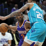 
              Phoenix Suns guard Chris Paul (3) looks to pass around Charlotte Hornets forward P.J. Washington (25) during the second half of an NBA basketball game, Tuesday, Jan. 24, 2023, in Phoenix. (AP Photo/Matt York)
            