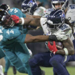 
              Tennessee Titans running back Derrick Henry is stopped for a loss by Jacksonville Jaguars linebacker Travon Walker (44) in the second half of an NFL football game, Saturday, Jan. 7, 2023, in Jacksonville, Fla. (AP Photo/Phelan M. Ebenhack)
            