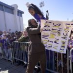 
              Seimone Augustus, a former LSU player who lead her team to multiple final fours and a Minnesota Lynx player who won four WNBA Championships, picks a young fan out of the crowd before her statue unveiling at the LSU campus on Sunday, Jan. 15, 2023, in Baton Rouge, La. (AP Photo/Matthew Hinton)
            