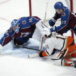 
              Colorado Avalanche goaltender Pavel Francouz, left, reaches out to cover the puck after stopping a shot by Anaheim Ducks center Trevor Zegras, as Avalanche defensemen Brad Hunt, back center, and Andreas Englund cover during the first period of an NHL hockey game Thursday, Jan. 26, 2023, in Denver. (AP Photo/David Zalubowski)
            