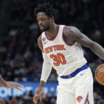 
              New York Knicks forward Julius Randle (30) controls the ball next to Detroit Pistons center Isaiah Stewart during the second half of an NBA basketball game, Sunday, Jan. 15, 2023, in Detroit. (AP Photo/Carlos Osorio)
            