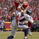 
              Kansas City Chiefs tight end Travis Kelce (87) leaps over Denver Broncos cornerback Damarri Mathis after catching a pass during the first half of an NFL football game Sunday, Jan. 1, 2023, in Kansas City, Mo. (AP Photo/Ed Zurga)
            