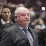 
              Vancouver Canucks coach Bruce Boudreau stands behind the bench before the team's NHL hockey game against the Edmonton Oilers on Saturday, Jan. 21, 2023, in Vancouver, British Columbia. (Darryl Dyck/The Canadian Press via AP)
            