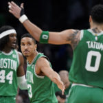 
              Boston Celtics guard Malcolm Brogdon, center, celebrates with forward Jayson Tatum (0) after their team scored while center Robert Williams III (44) looks on in the second half of an NBA basketball game against the Golden State Warriors, Thursday, Jan. 19, 2023, in Boston. (AP Photo/Steven Senne)
            