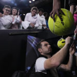 
              Andy Murray of Britain signs autographs as he leaves Margaret Court Arena in the early hours of Friday Jan. 20, 2023 following his five set win over Australia's Thanasi Kokkinakis at the Australian Open tennis championships in Melbourne, Australia. (AP Photo/Ng Han Guan)
            