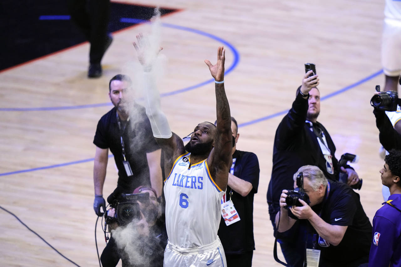 Los Angeles Lakers' LeBron James tosses powder before an NBA basketball game against the New York K...