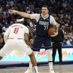 
              Dallas Mavericks guard Luka Doncic (77) points directions to teammates as Los Angeles Clippers forward Marcus Morris Sr. (8) guards against him during the second half of an NBA basketball game in Dallas, Sunday, Jan. 22, 2023. (AP Photo/LM Otero)
            