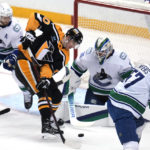 
              Pittsburgh Penguins' Drew O'Connor (10) tries to get a shot off in front of Vancouver Canucks goaltender Spencer Martin (30) during the first period of an NHL hockey game in Pittsburgh, Tuesday, Jan. 10, 2023. (AP Photo/Gene J. Puskar)
            