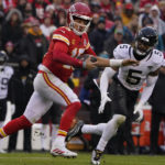 
              Kansas City Chiefs quarterback Patrick Mahomes (15) runs out of the pocket as Jacksonville Jaguars safety Andre Cisco (5) defends during the first half of an NFL divisional round playoff football game, Saturday, Jan. 21, 2023, in Kansas City, Mo. Mahomes was injured after the play. (AP Photo/Ed Zurga)
            