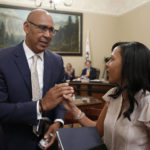 
              FILE - Democratic Assembly members Chris Holden, of Pasadena, left, and Autumn Burke, of Marina del Rey, shake hands after the wildfire bill they co-authored, with Assemblyman Chad Mayes, R-Yucca Valley, was approved by Senate committee in Sacramento, Calif., Monday, July 8, 2019. A California lawmaker introduced a bill Thursday, Jan. 19, 2023, that would require schools that play major college sports to pay some athletes as much as $25,000 annually, along with covering the cost of six-year guaranteed athletic scholarships and post-college medical expenses. The College Athlete Protection Act is sponsored by Assembly member Chris Holden. (AP Photo/Rich Pedroncelli, File)
            