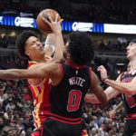 
              Atlanta Hawks' Jalen Johnson collides with Chicago Bulls' Coby White as Alex Caruso watches during the first half of an NBA basketball game Monday, Jan. 23, 2023, in Chicago. (AP Photo/Charles Rex Arbogast)
            